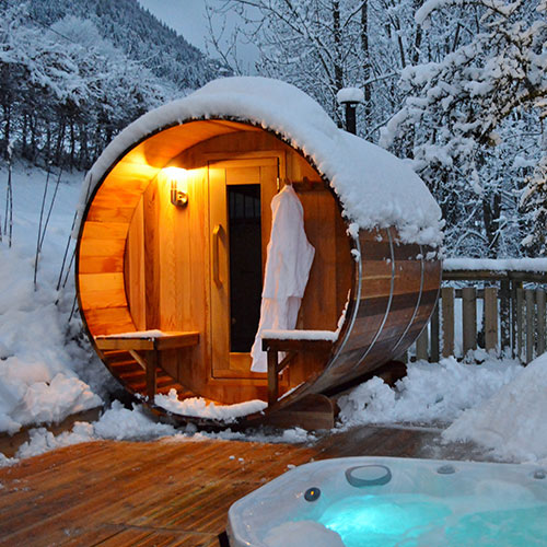 Couple using an outdoor sauna in snowy weather